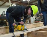 Man cutting a board with an electric saw Man cutting a board with an electric saw